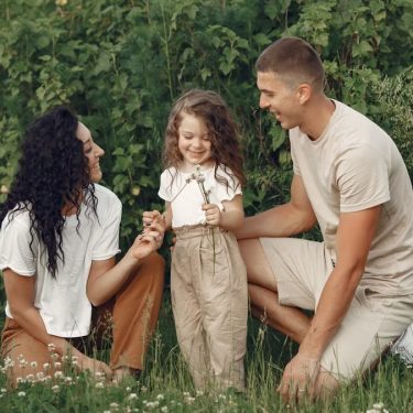 A joyful family enjoying time together in a lush green field.